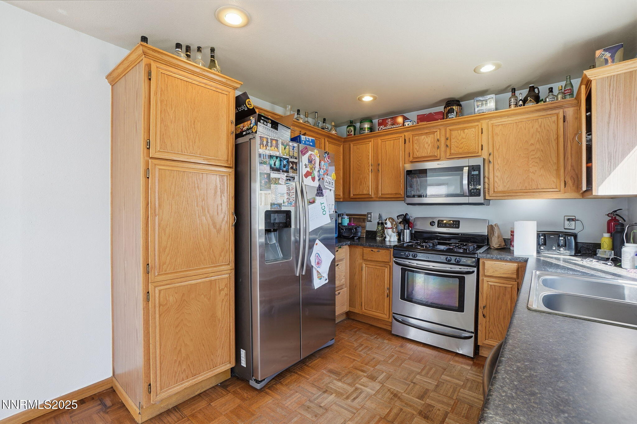 8486 Piper Place Reno, NV 89506 - Photo 12 of 25 a kitchen with stainless steel appliances granite countertop a refrigerator a stove a sink a washer dryer and white cabinets