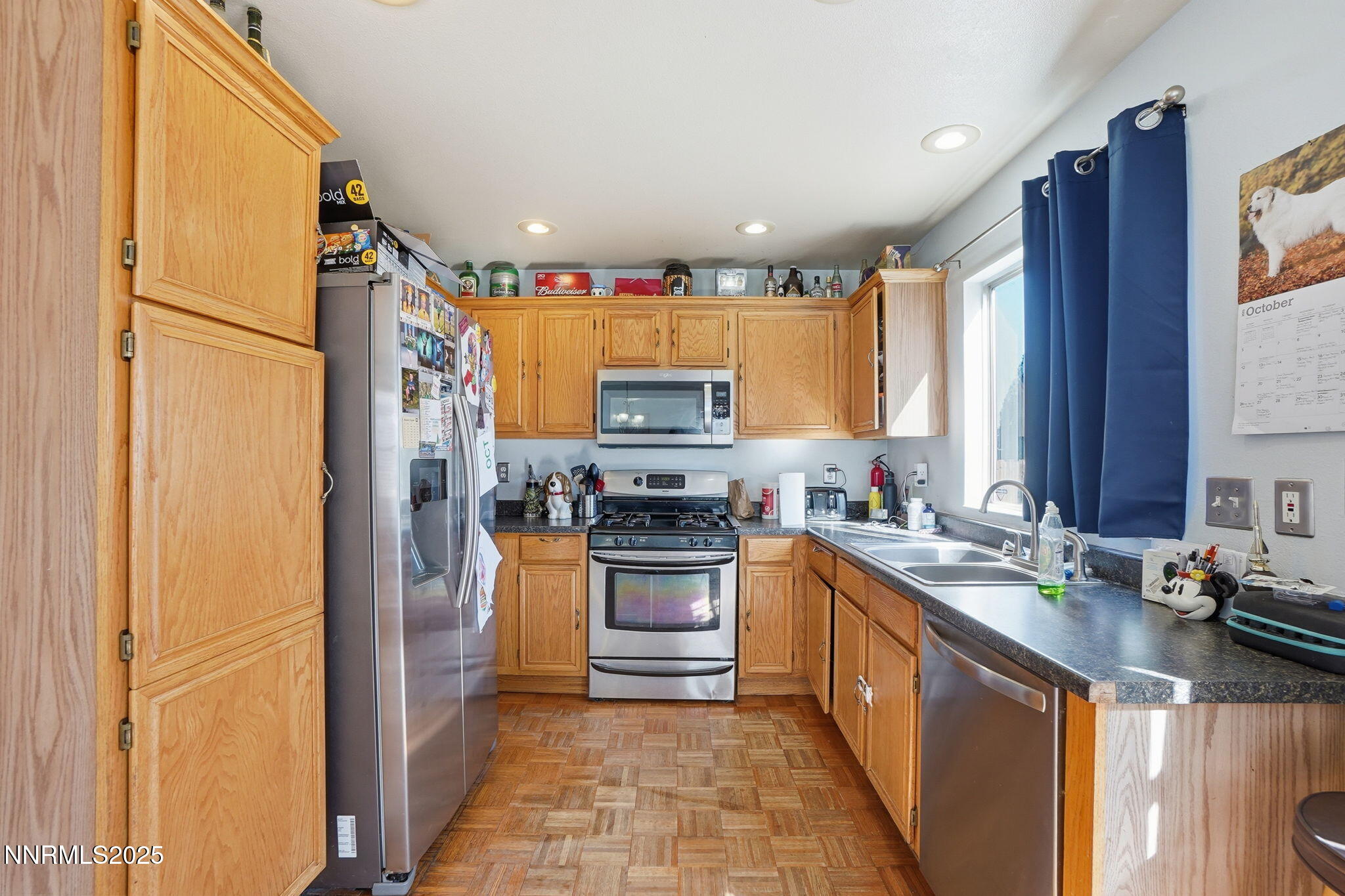 8486 Piper Place Reno, NV 89506 - Photo 10 of 25 a kitchen with stainless steel appliances granite countertop a refrigerator a sink dishwasher a stove and a dining table with wooden cabinet