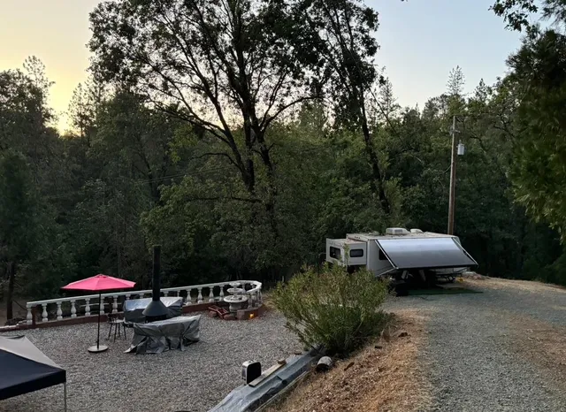 a view of a backyard with table and chairs under an umbrella