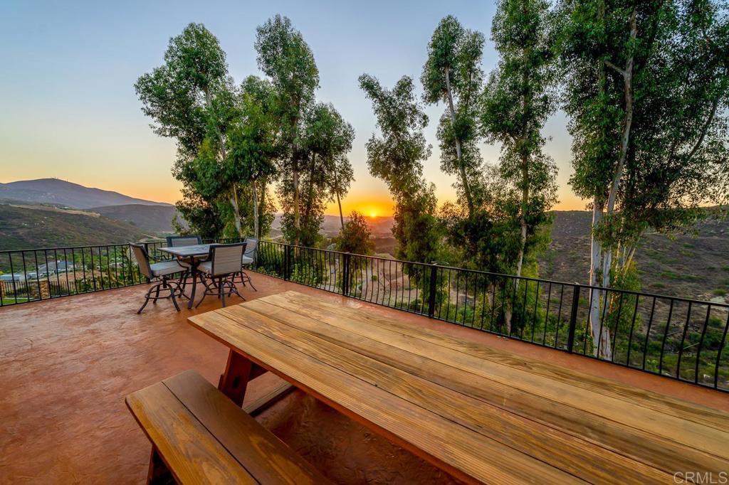 14062 Jamacha Hills Road Jamul, CA 91935 - Photo 24 of 39 a view of a patio with table and chairs under an umbrella with wooden floor