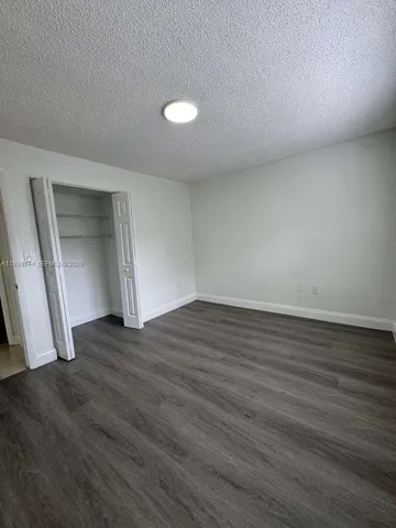 an empty room with wooden floor and door