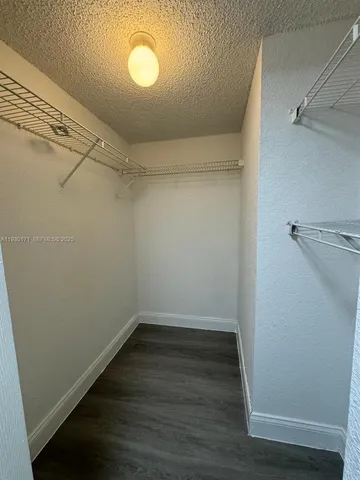 a view of a room with wooden floor and white walls
