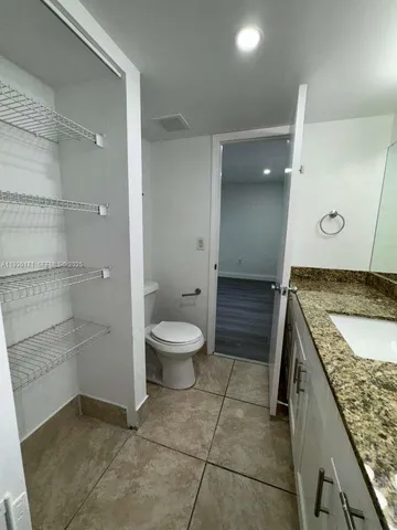 a bathroom with a granite countertop sink a toilet and shower