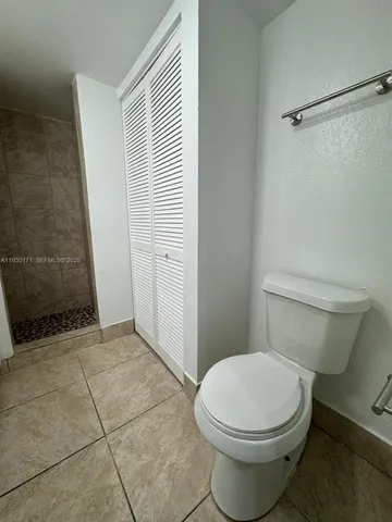 a white toilet sitting next to a shower