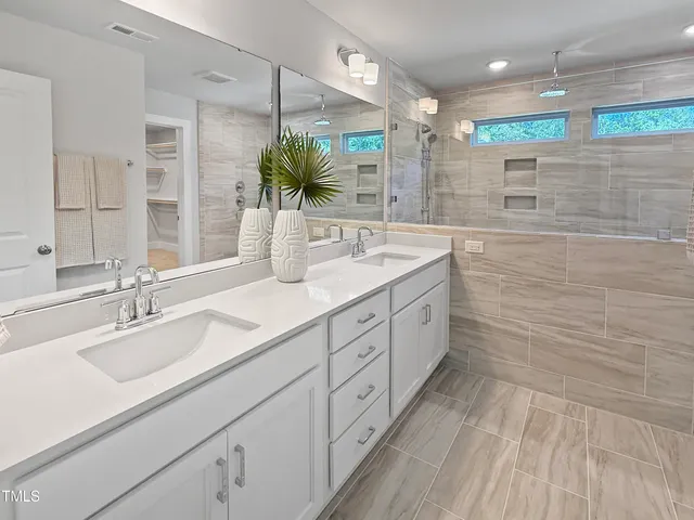 a bathroom with a double vanity sink and a shower