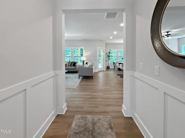 a hall way with furniture and a mirror