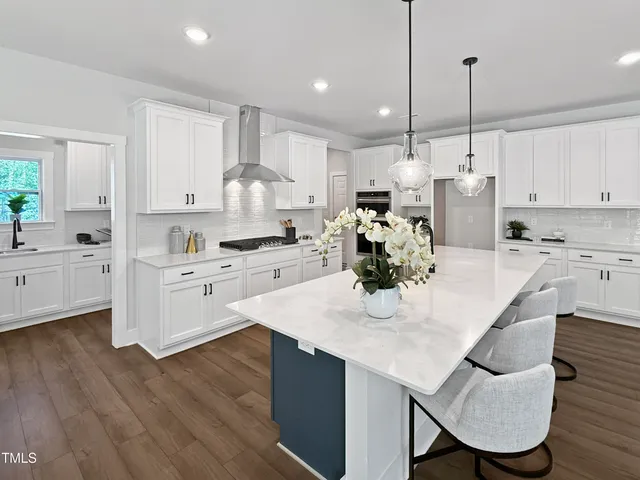 a kitchen with kitchen island granite countertop a white cabinets and refrigerator