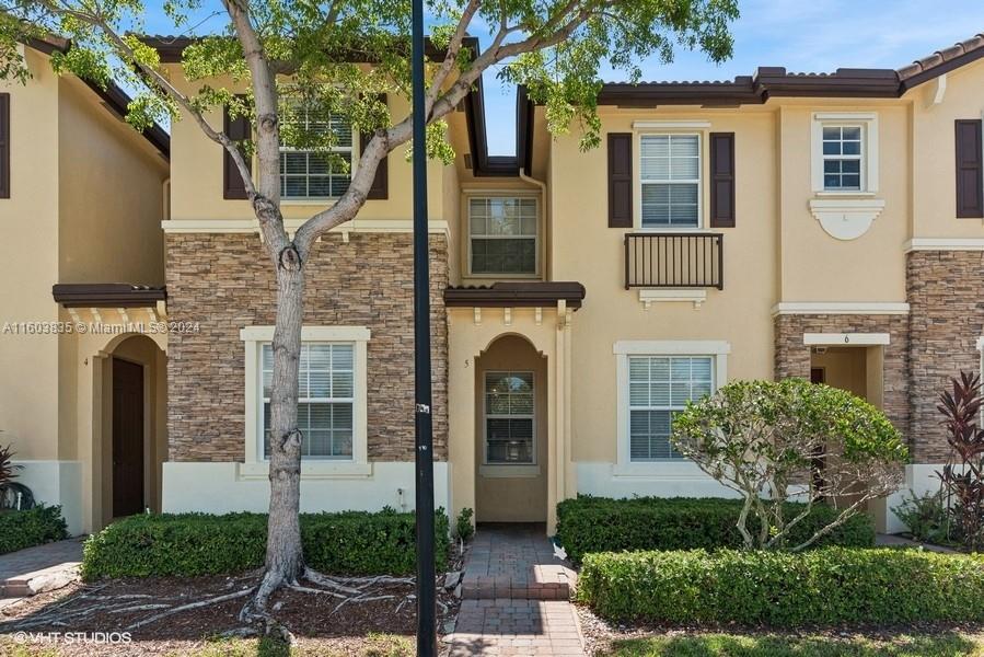 9165 Southwest 227th Street, Unit 5 Cutler Bay, FL 33190 - Photo 1 of 26 a front view of a house with plants and garden