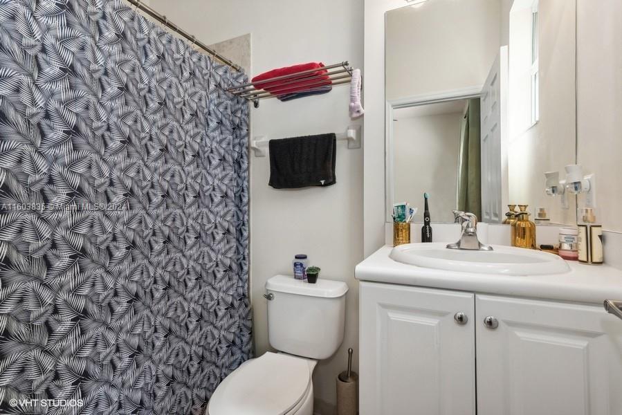 9165 Southwest 227th Street, Unit 5 Cutler Bay, FL 33190 - Photo 11 of 26 a bathroom with a sink toilet and mirror