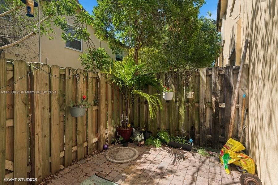 9165 Southwest 227th Street, Unit 5 Cutler Bay, FL 33190 - Photo 15 of 26 a view of a backyard with potted plants and wooden fence