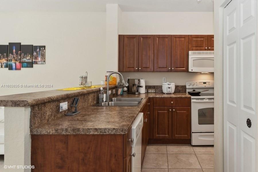 9165 Southwest 227th Street, Unit 5 Cutler Bay, FL 33190 - Photo 19 of 26 a kitchen with stainless steel appliances granite countertop a sink a stove and a refrigerator