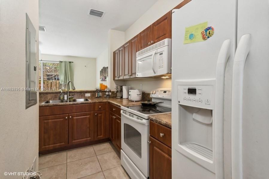 9165 Southwest 227th Street, Unit 5 Cutler Bay, FL 33190 - Photo 20 of 26 a kitchen with a white cabinets and white appliances