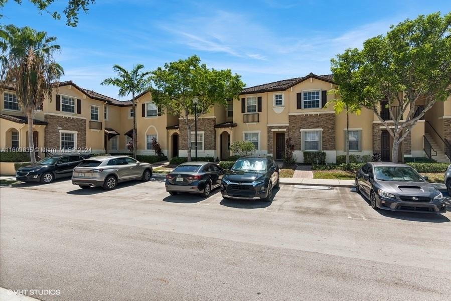 9165 Southwest 227th Street, Unit 5 Cutler Bay, FL 33190 - Photo 2 of 26 a view of a car park in front of a building