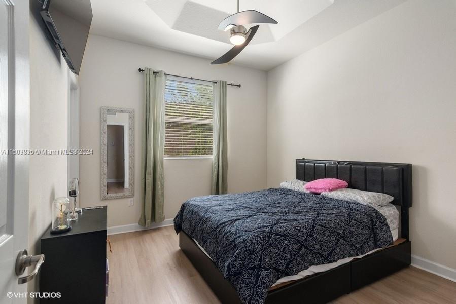 9165 Southwest 227th Street, Unit 5 Cutler Bay, FL 33190 - Photo 10 of 26 a bedroom with a bed and wooden floor