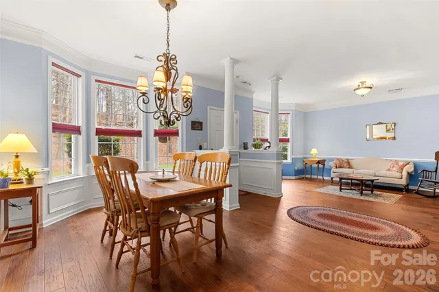 a dining room with furniture a chandelier and wooden floor