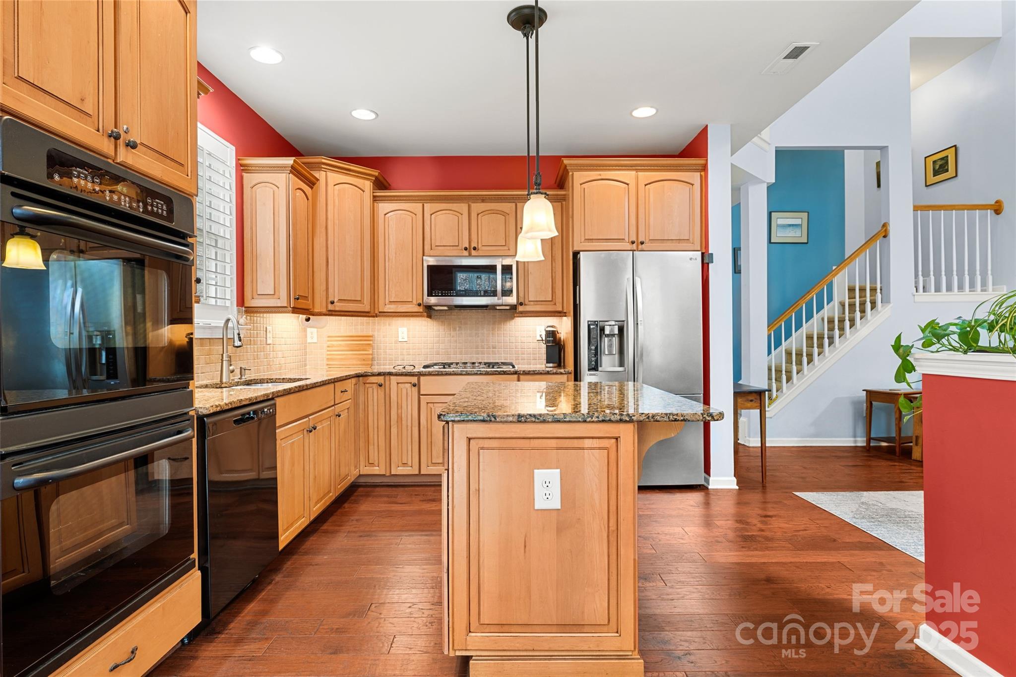 719 Deerbrook Lane Tega Cay, SC 29708 - Photo 10 of 33 a kitchen with stainless steel appliances granite countertop a refrigerator a stove and a wooden floors