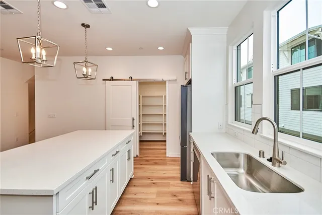 a kitchen with a sink and wooden floor