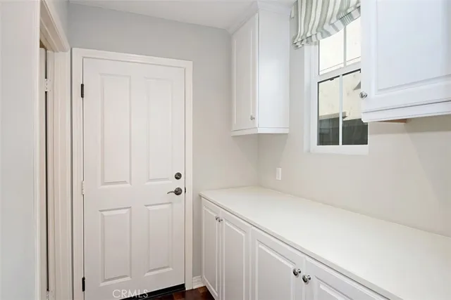 a utility room with granite countertop cabinets