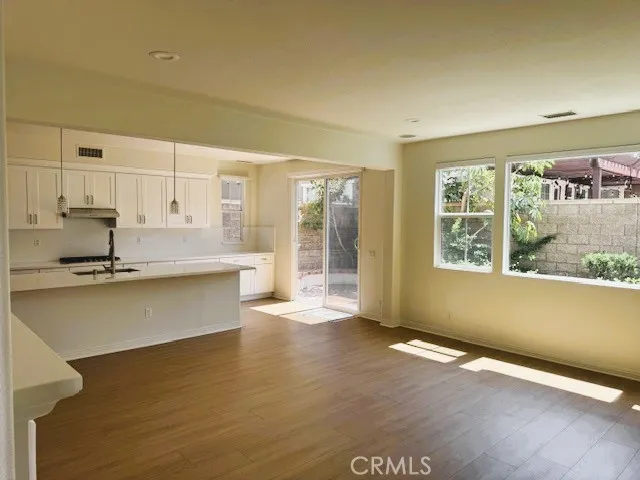 a view of a kitchen with wooden floor and a window