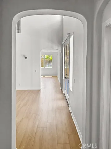 a view of a hallway with wooden floor and staircase