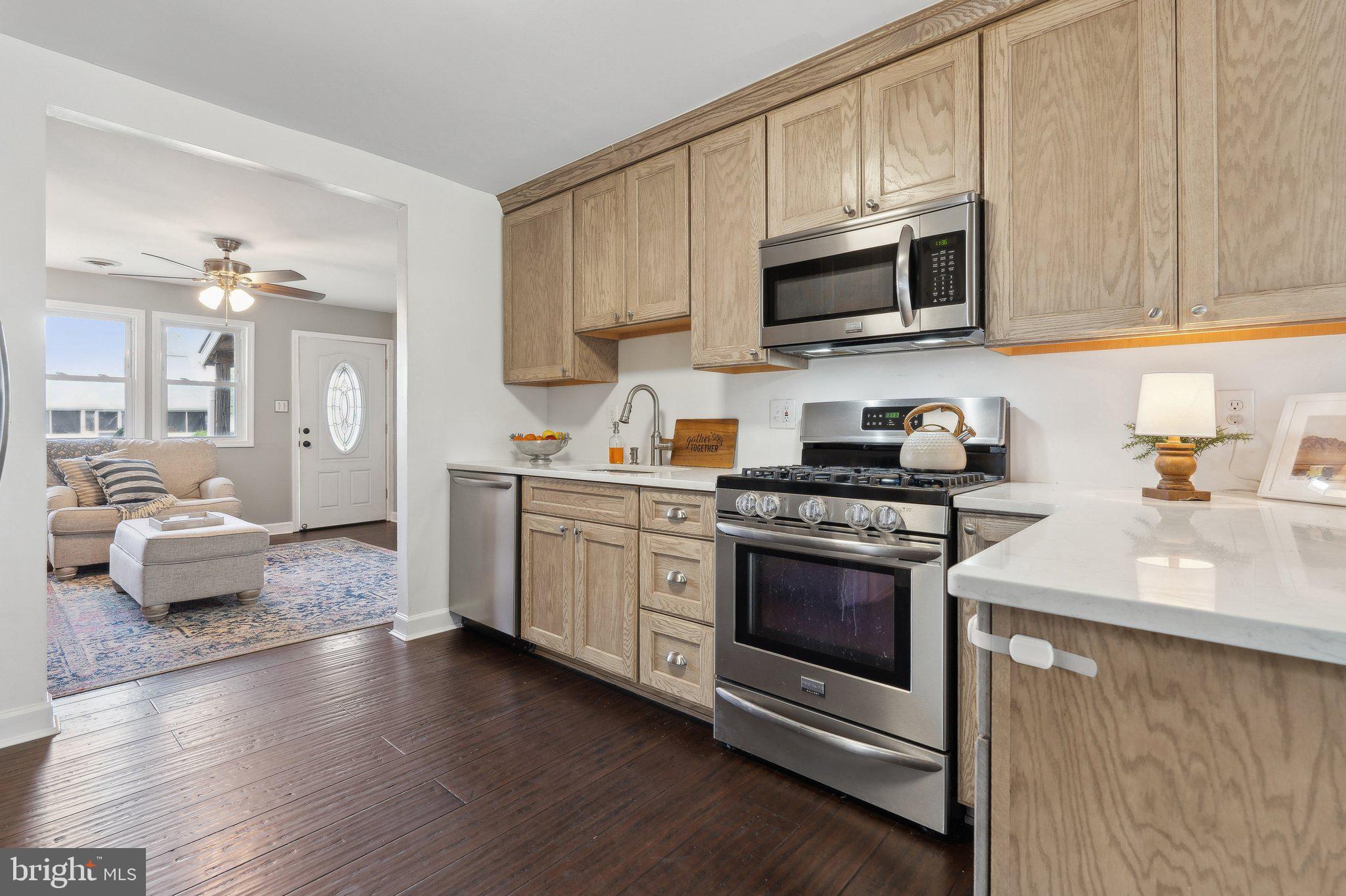 937 Winding Road Edgewater, MD 21037 - Photo 12 of 42 a kitchen with stainless steel appliances granite countertop a sink dishwasher stove and microwave with wooden floor