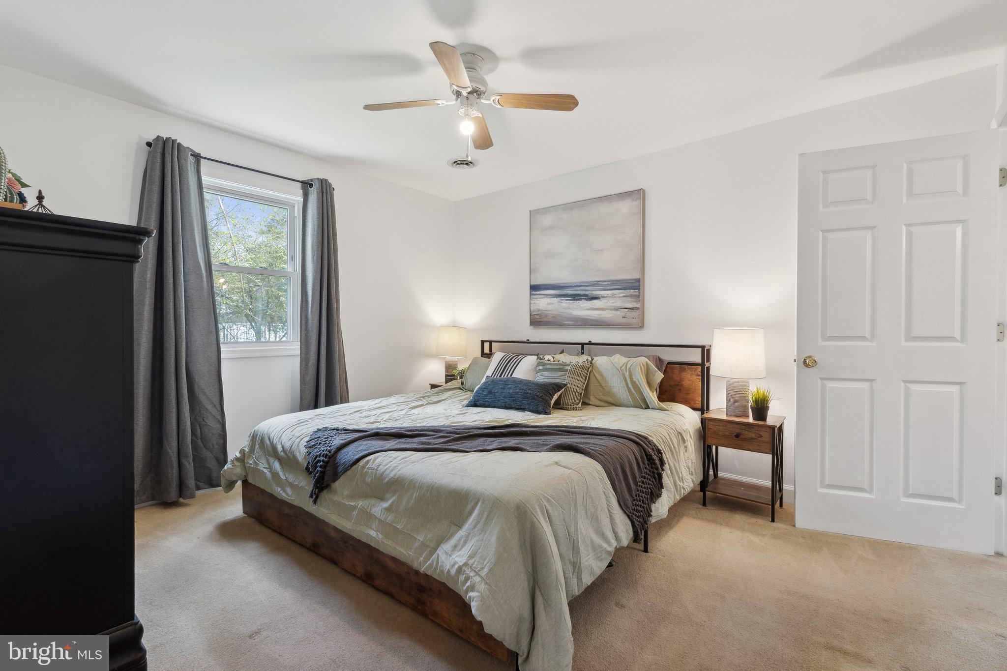 937 Winding Road Edgewater, MD 21037 - Photo 16 of 42 a bedroom with a bed ceiling fan and a window