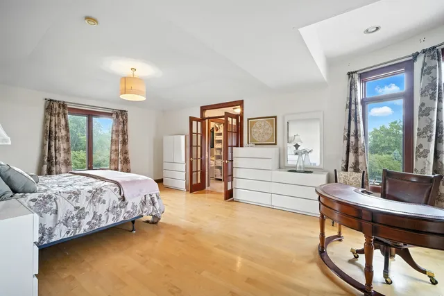 a bedroom with a bed and a large window