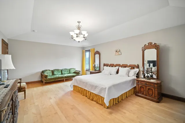 a spacious bedroom with a bed a couch and dresser