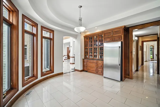 a view of a hallway with windows and chandelier