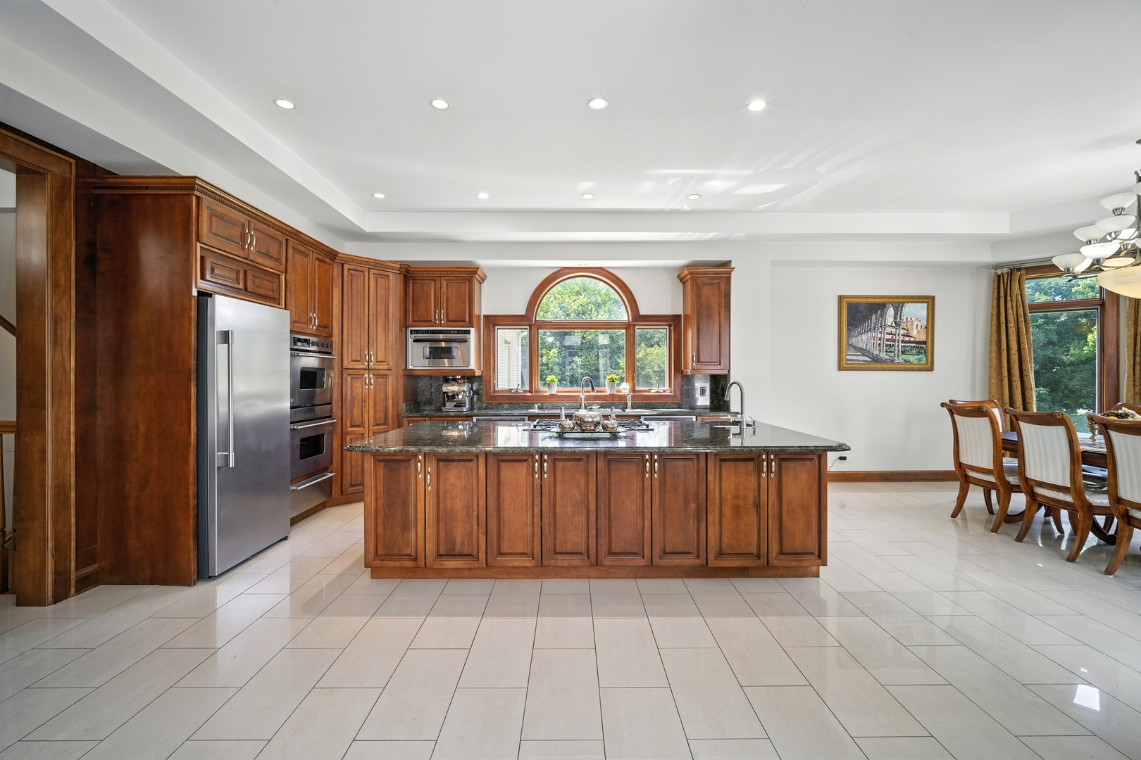 1100 MacAlpin Drive Inverness, IL 60010 - Photo 32 of 50 a large kitchen with stainless steel appliances granite countertop a refrigerator a sink dishwasher a dining table and chairs with wooden floor
