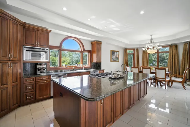a kitchen with stainless steel appliances granite countertop a sink a stove and a refrigerator