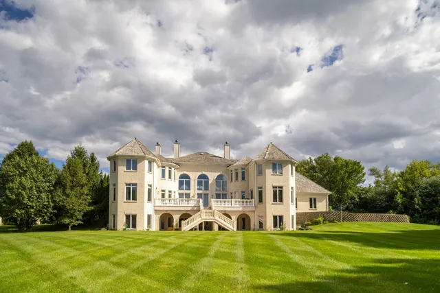 a front view of a house with a garden and trees
