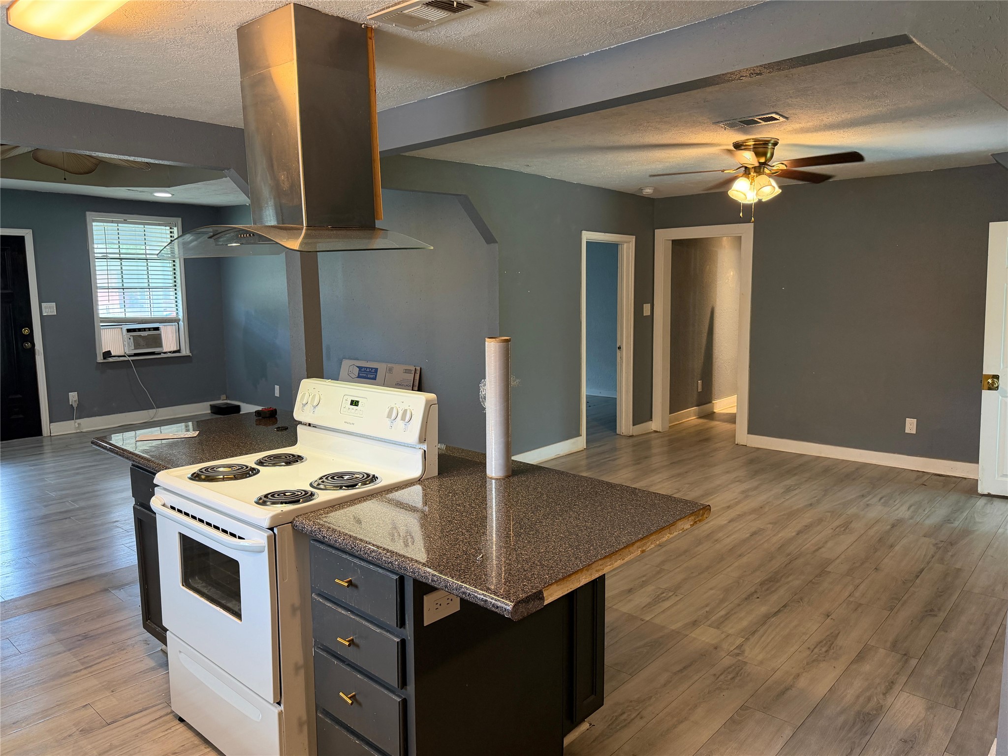 1401 East 29th Street Bryan, TX 77802 - Photo 5 of 13 A functional kitchen island anchors this open-concept living space with resilient flooring.