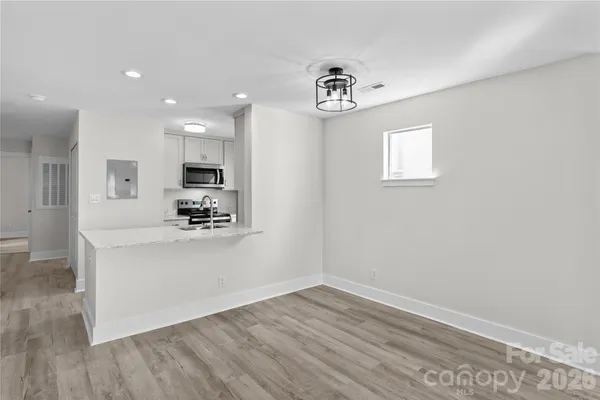 a view of a livingroom with a ceiling fan wooden floor and window