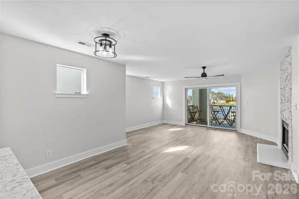 wooden floor fireplace and windows in an empty room