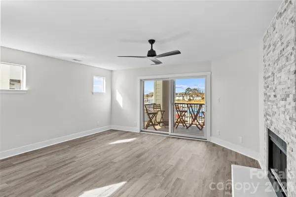 a view of empty room with wooden floor and fireplace