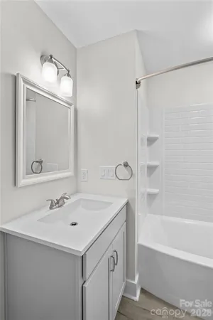 a white toilet and tub sitting next to a bathroom sink