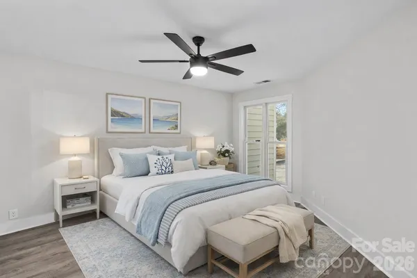 an empty room with wooden floor ceiling fan and windows