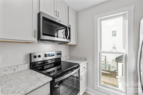 a kitchen with stainless steel appliances granite countertop a sink and a refrigerator