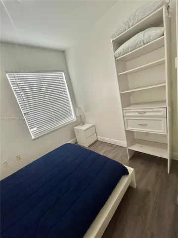 a view of bedroom with wooden floor and windows