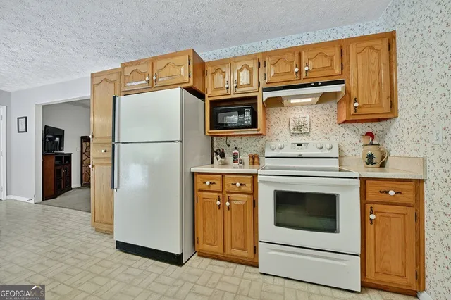 a kitchen with stainless steel appliances granite countertop a refrigerator stove and a sink
