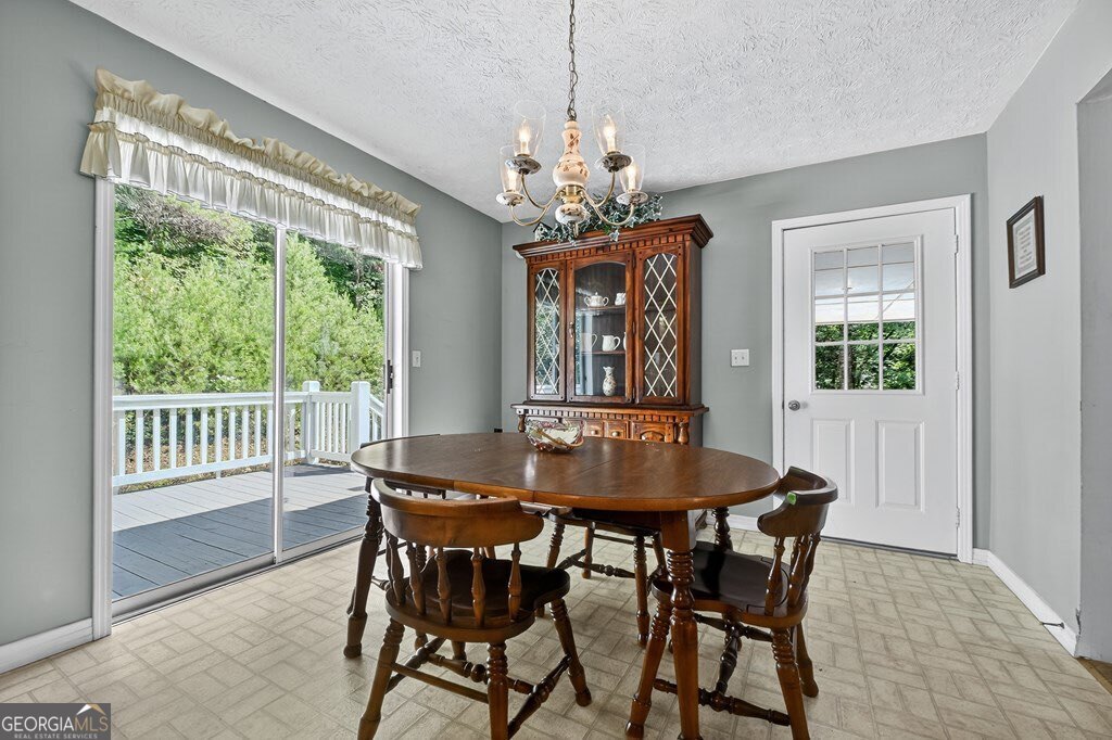 1362 Cherry Log Street Cherry Log, GA 30522 - Photo 16 of 55 a dining room with furniture a chandelier and wooden floor