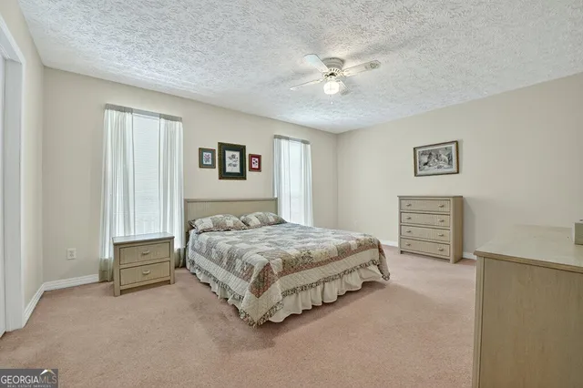 a spacious bedroom with a bed and a chandelier