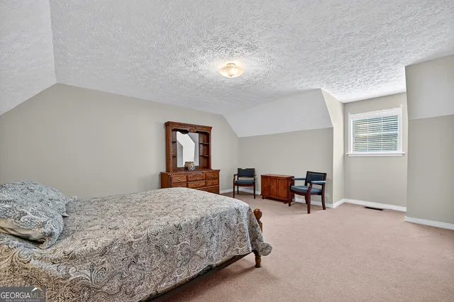 a bedroom with a bed and a table in it with window