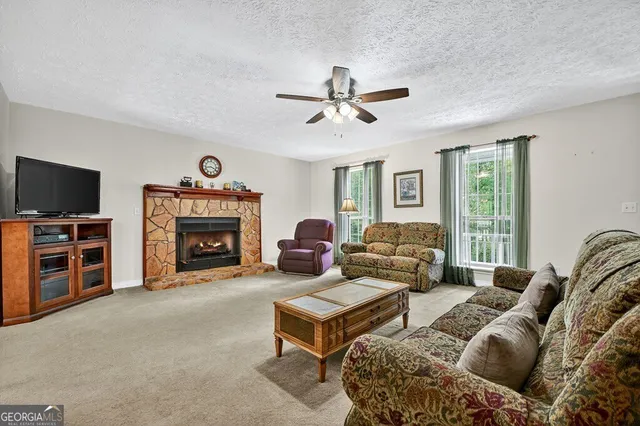a living room with furniture a flat screen tv and a fireplace