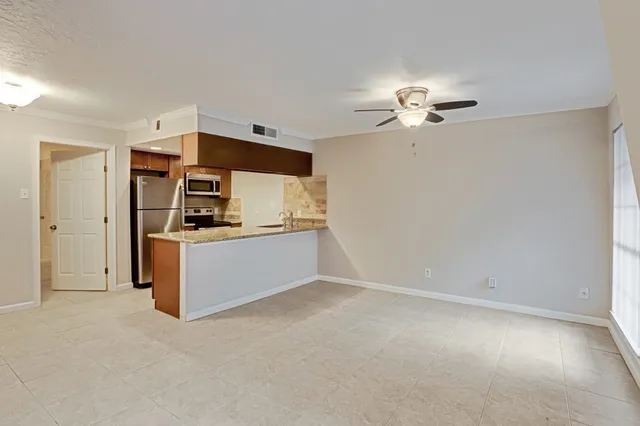 a kitchen with granite countertop a refrigerator and a sink