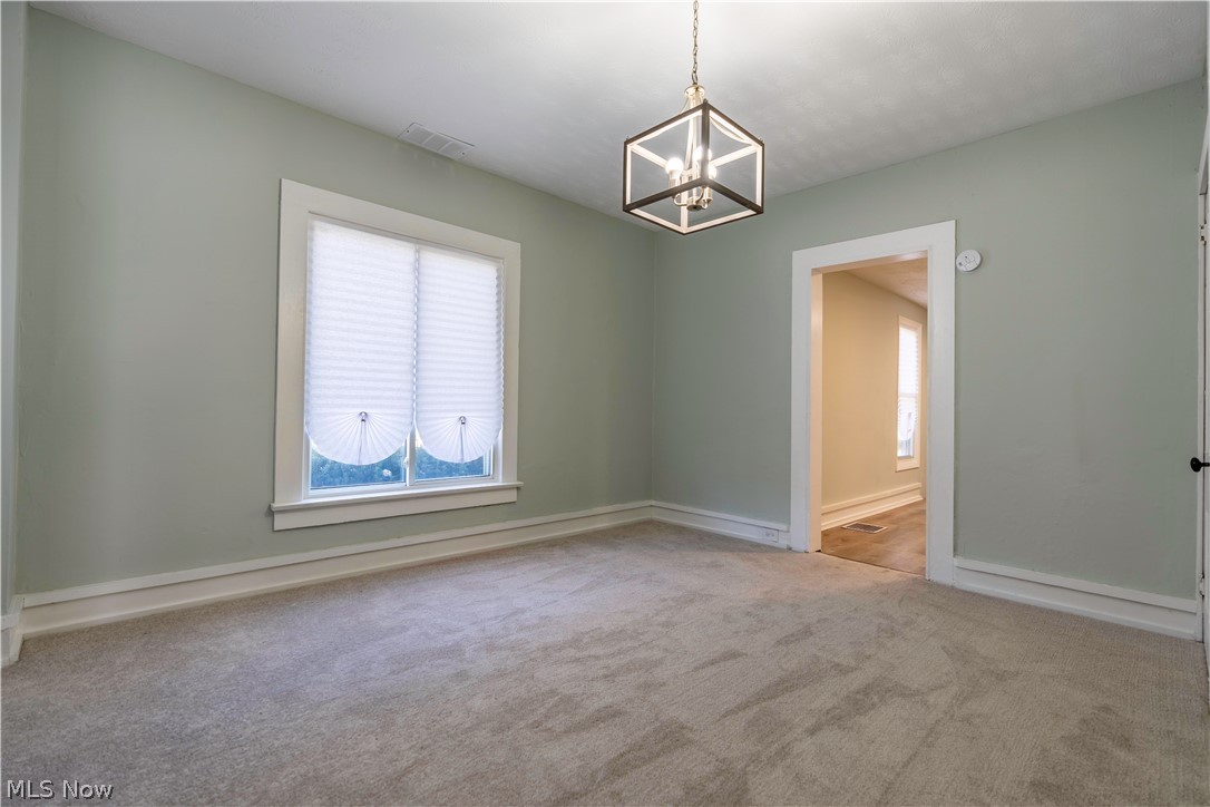 635 Mill Road Ravenna, OH 44266 - Photo 6 of 37 Carpeted spare room featuring an inviting chandelier