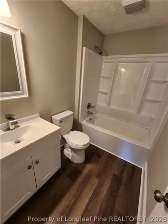 a bathroom with a bathtub shower sink vanity and toilet