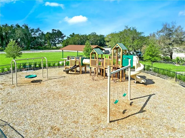 a kitchen with stainless steel appliances kitchen island granite countertop a sink a stove a table and chairs