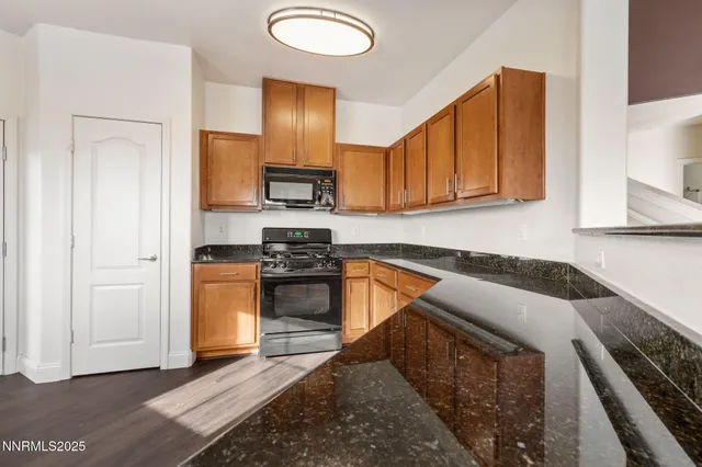 a kitchen with stainless steel appliances granite countertop a stove a sink and a refrigerator
